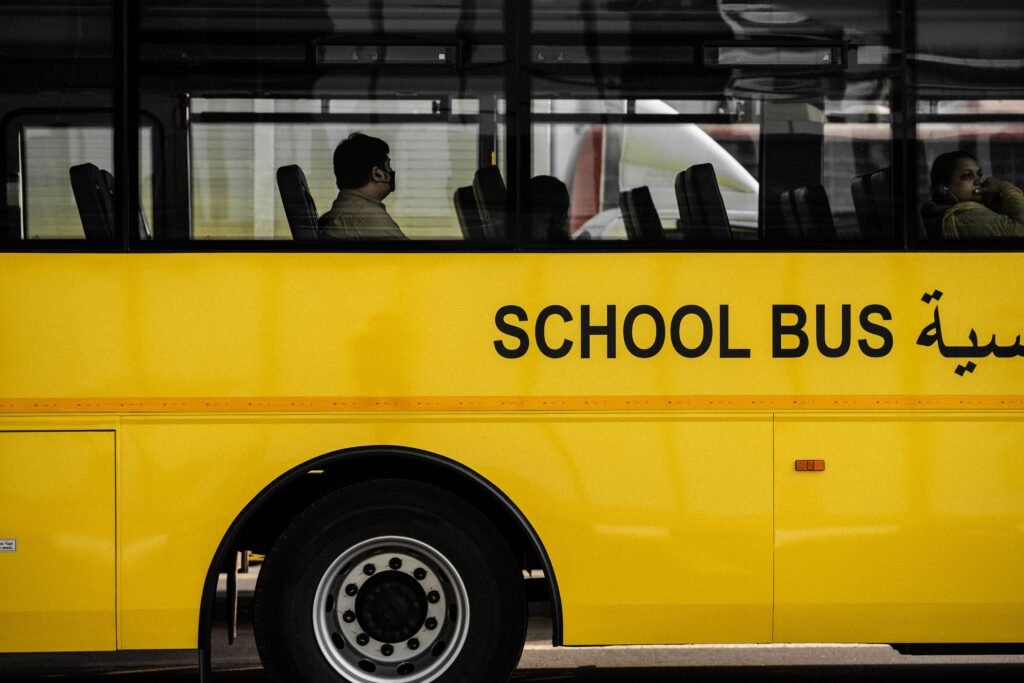 A modern yellow school bus with passengers seen through the windows. Ideal for urban transportation themes.